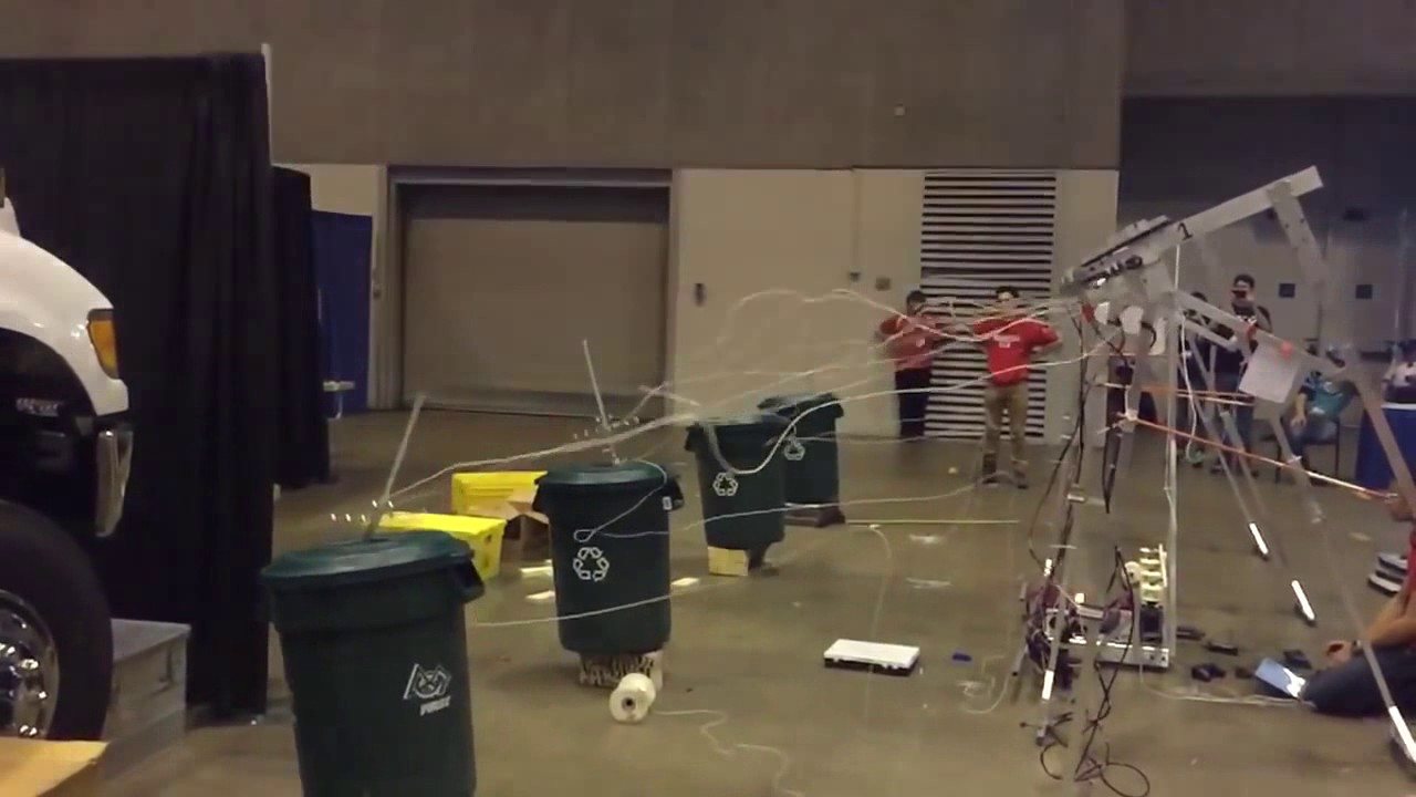 Crossbow tripods on the right firing bolts, trailing lines, into four green bins