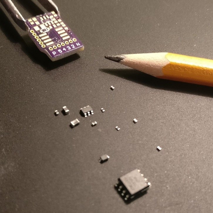 Bare purple circuit board held in tweezers beside loose surface-mount parts and a pencil tip