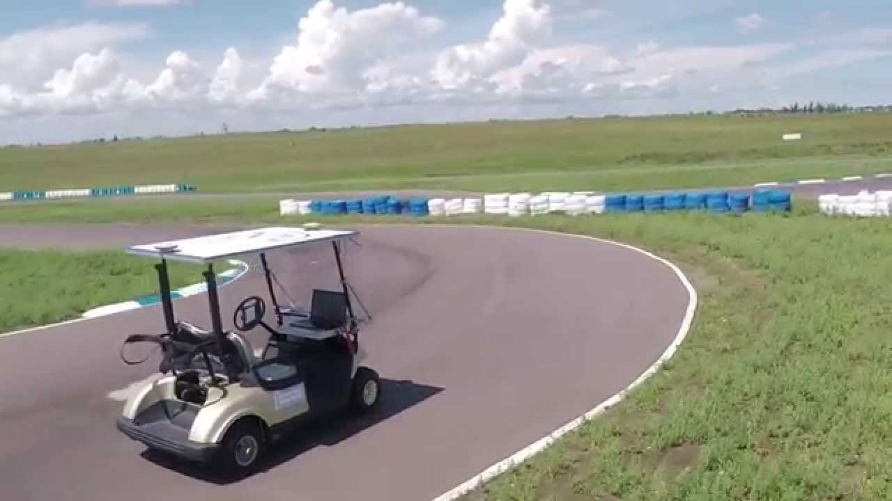 Gen 1 golf cart on a paved track with nobody on board, a laptop mounted beside the steering wheel